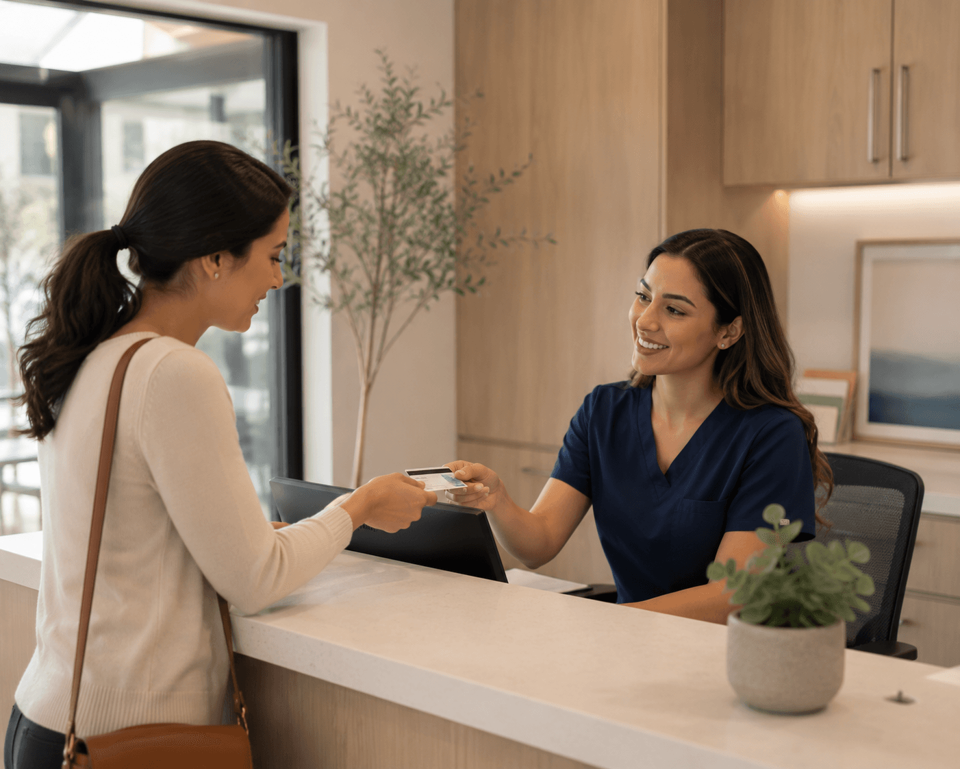 Front desk staff accepting an insurance card from a patient